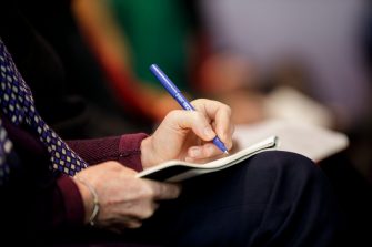Photograph of someone writing in a book